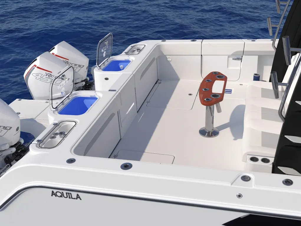 Aquila boat cockpit featuring twin outboard engines, a console with multiple rod holders, storage compartments, and sea view.